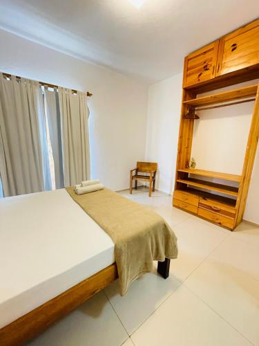 a bedroom with a bed and a chair in it at Villa Mar Residence in Jericoacoara