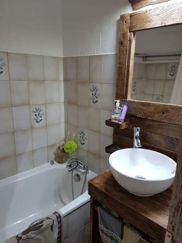 une salle de bain avec un lavabo, une baignoire et un miroir dans l'établissement Studio agréable, aux Contamines-Montjoie