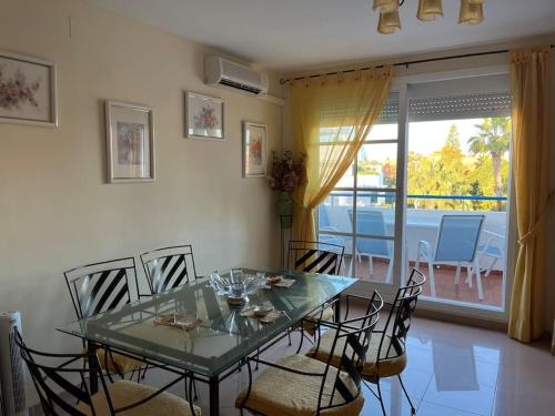 a dining room with a glass table and chairs at Apartamento en Costa Ballena, Urb. Playa Ballena in Cádiz