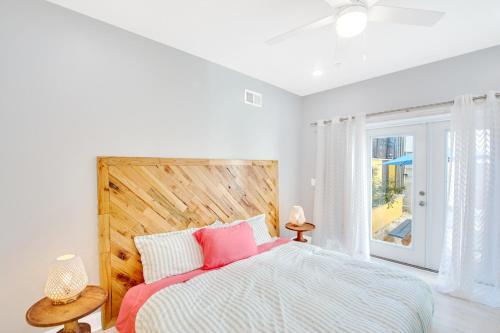 Un dormitorio con una cama con almohadas rosas y una ventana en Spacious Oasis - Parking, Private Patio & Roofdeck en Filadelfia