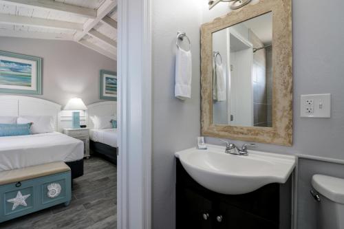 Fiesta Key RV Resort Premium Room 3 في لايتون: حمام مع حوض ومرآة وسرير