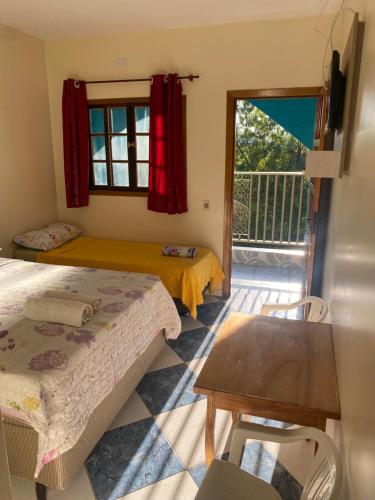 a bedroom with two beds and a balcony at Pousada 277 in Foz do Iguaçu
