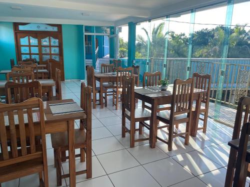 un restaurante con mesas y sillas y un balcón en Pousada 277, en Foz do Iguaçu