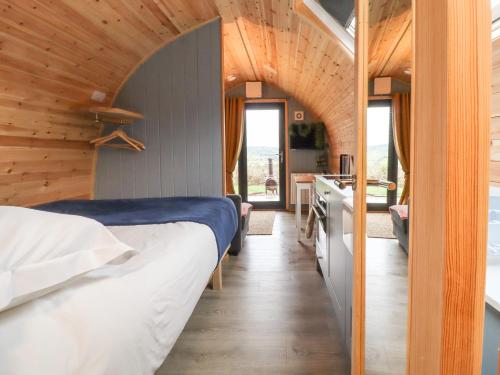 een slaapkamer met een bed in een kamer met houten wanden bij Whernside in Clitheroe