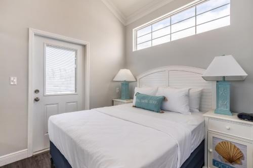 a white bedroom with a large bed and a window at Fiesta Key RV Resort Waterfront Cottage 33 in Layton