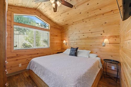 1 dormitorio con 1 cama en una cabaña de madera en Deluxe little cabin 2 min stroll to Kern River, en Kernville