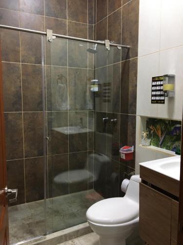 a bathroom with a shower with a toilet and a sink at Hotel Boutique el Sol in Cartago