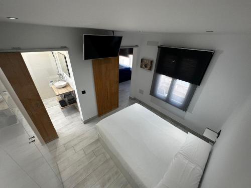 a bedroom with a white bed and a bathroom at Princesa 202 in Puerto del Carmen