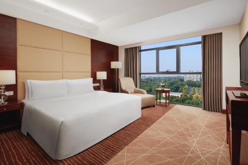 a bedroom with a white bed and a large window at Crowne Plaza Beijing International Airport, an IHG Hotel in Shunyi