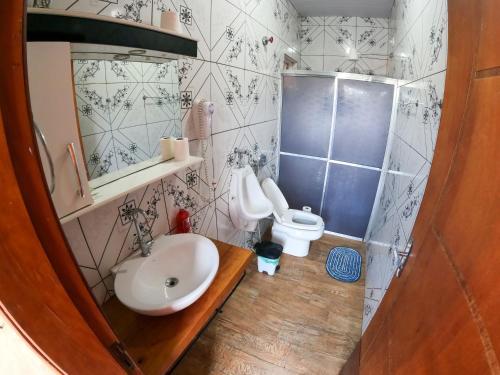 a bathroom with a sink and a toilet at Casa Victour, localização privilegiada in Bonito