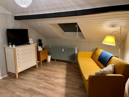 Dielheim的住宿－Ihr Zuhause im Herzen von Baden，客厅设有黄色沙发和电视