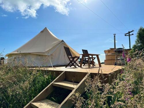 a tent with a table and a chair on a deck at Studholme Glamping in Hunter