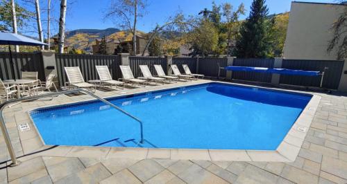 a large swimming pool with chairs next to a fence at 3Bdr in the heart of lions head Ski locker in Vail