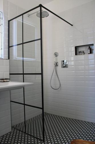 a shower in a white bathroom with a sink at Ferienwohnung GeestZuhause in Heeslingen