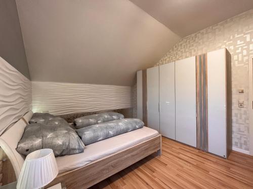 Un dormitorio con una cama con almohadas encima. en A&D Ferienwohnung Elsasser Blick - Bühlertal bei Bühl, Baden-Baden & Schwarzwald, en Bühlertal