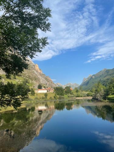 uma vista para um rio com árvores e montanhas em Apartamentos Rurales La Casina del Fontan em Valle de Lago