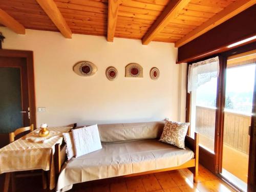 Falcade Dolomiti La Quiete Mansarda panoramica في Fregona: غرفة معيشة مع أريكة وطاولة