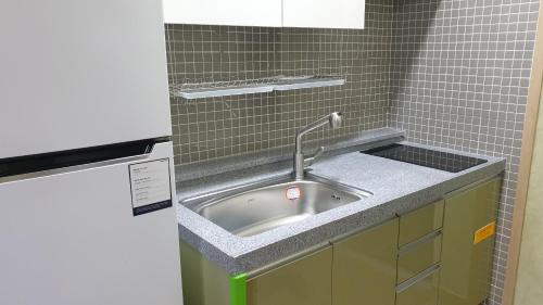 a kitchen sink with a faucet in a bathroom at Travel Sketch Pension in Geoje