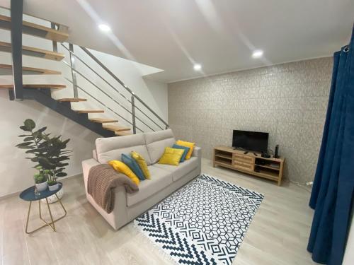 a living room with a couch and a television at Casa da Ribeira - Mosteiros in Mosteiros
