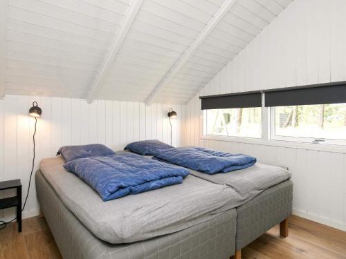 ブラーバンドにあるFour-Bedroom Holiday home in Blåvand 42のベッドルーム1室(青い枕のベッド1台付)