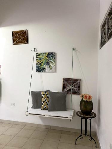 a hanging bench in a room with a vase on a table at Luna Cartagena Airport Hotel in Cartagena de Indias