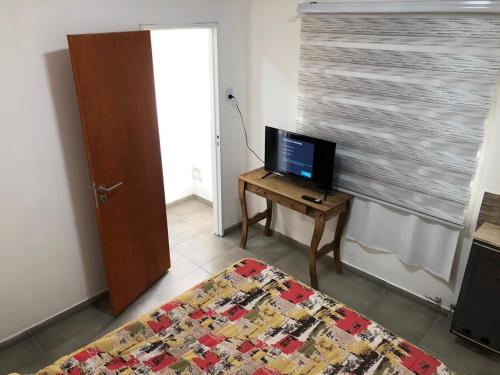 a bedroom with a bed and a television on a table at Vientos del Sur in Río Gallegos