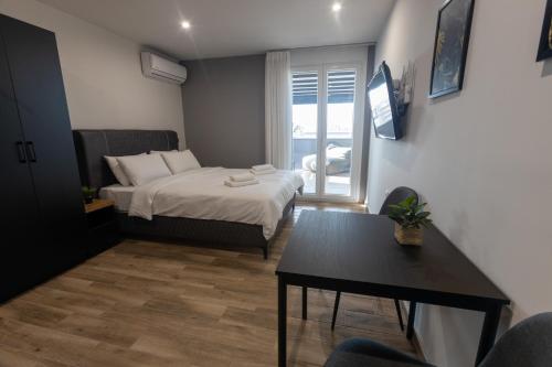 Kleines Zimmer mit einem Bett und einem Tisch in der Unterkunft Raise Athens Metro Apartments in Athen