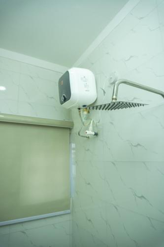 a shower in a bathroom with a light on the wall at Discover 8-Bedrooms Lakeside Apartment Living Free Starlink SuperFast Speed WiFi And Well Secured in Amuwo