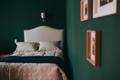 a green bedroom with a bed with two pillows at Anden Inca Hotel in Cusco