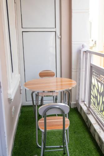 a table and two chairs on a balcony with green grass at Discover 8-Bedrooms Lakeside Apartment Living Free Starlink SuperFast Speed WiFi And Well Secured in Amuwo