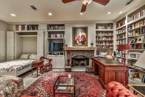 a living room with a fireplace and a room with a bed and a couch at Artist's Library with a Private Swimming Pool in Houston