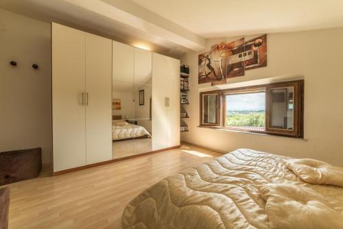 sypialnia z dużym łóżkiem i oknem w obiekcie Villa Leonardo w mieście Sarteano