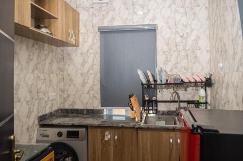 a kitchen with a sink and a counter top at Discover 8-Bedrooms Lakeside Apartment Living Free Starlink SuperFast Speed WiFi And Well Secured in Amuwo