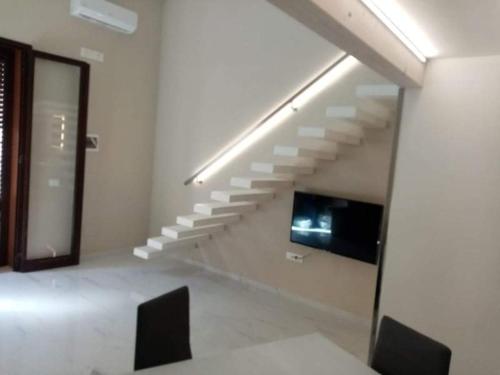 a room with a staircase and a tv in a building at Élite Lampedusa in Lampedusa