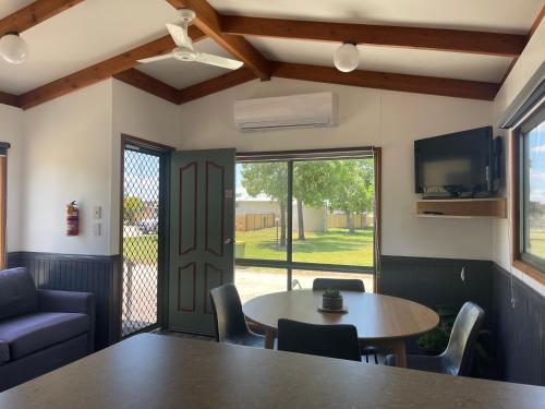 um quarto com uma mesa e cadeiras e uma janela em Kerang Holiday park em Kerang