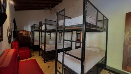 Habitación con 4 literas y sofá rojo. en Encuentros en Granada