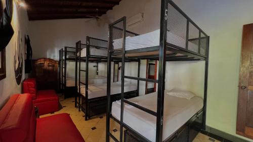 Habitación con 4 literas y sofá rojo. en Encuentros, en Granada