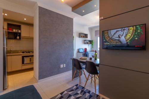 een keuken en een woonkamer met een televisie aan de muur bij OFERTA! Ensolarado no 13º andar CENTRAL Próx IMED Garagem in Passo Fundo