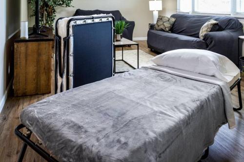 a large bed in a living room with a couch at {Quiet Suburban Ranch Hot Tub} Mins Arpt/RIT/DWNT in Rochester