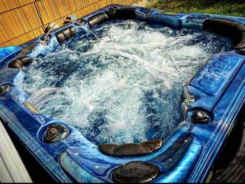 a blue bath tub with water in it at {Quiet Suburban Ranch Hot Tub} Mins Arpt/RIT/DWNT in Rochester