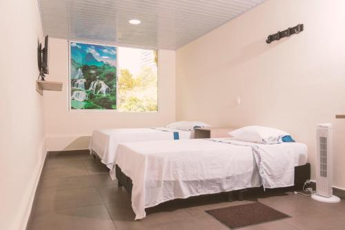 a hospital room with two beds and a painting on the wall at Vivienda turística Arboleda de Cádiz in Ibagué