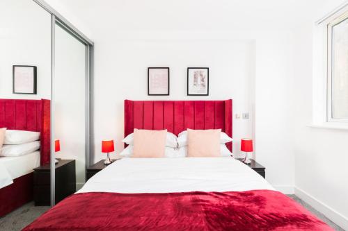 バーミンガムにあるNEWLY REFURBED - Central Granville Broad Street Apartmentsのベッドルーム1室(赤いヘッドボード付きの大型ベッド1台付)