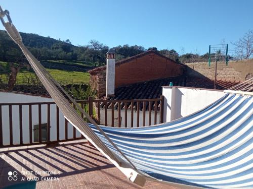 a hammock on a porch with a fence at El Corchuelo in Corteconcepción