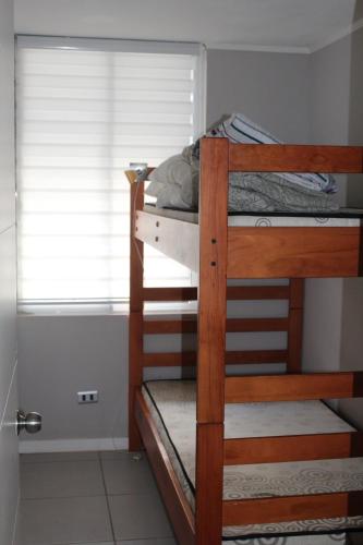 a bedroom with two bunk beds and a window at Departamento Familiar los Molles in Los Molles