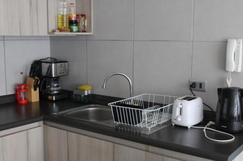 a kitchen counter with a sink and a toaster at Departamento Familiar los Molles in Los Molles
