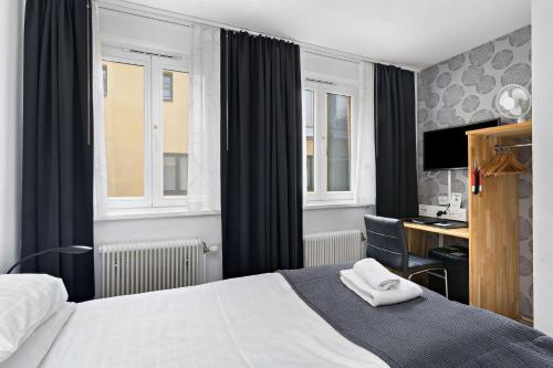 a hotel room with a bed and a desk and window at Best Western Hotel Anno 1937 in Kristianstad