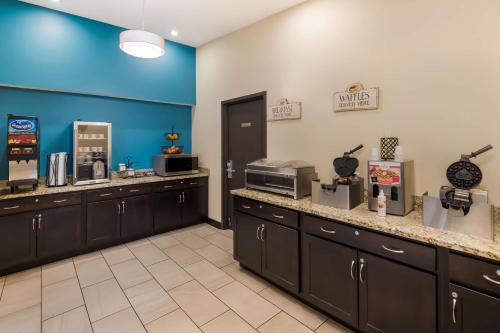a large kitchen with brown cabinets and a blue wall at SureStay Plus Hotel by Best Western Jasper in Jasper