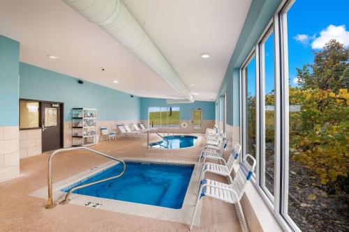 a house with a swimming pool with chairs around it at SureStay Plus Hotel by Best Western Jasper in Jasper