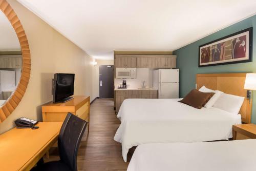 a hotel room with two beds and a desk at SureStay Plus Hotel by Best Western Jasper in Jasper