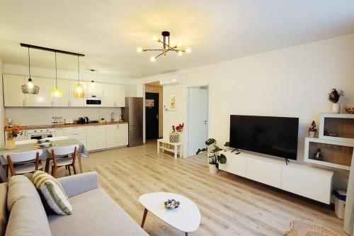 a living room with a couch and a tv and a kitchen at DN Green apartment in Budapest